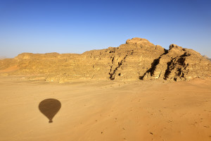 Shadow of hot-air balloon over the desert of Wadi Rum